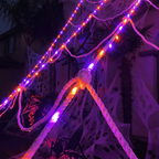 Close up of glowing purple and orange LED spider web rope strands at night