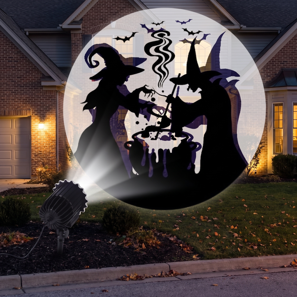 Halloween projector staked in a front yard projecting patterns onto a house at night