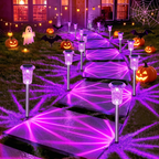 Purple solar pathway lights lining a Halloween decorated walkway with pumpkins at night