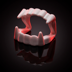 Vampire fangs costume teeth displayed dramatically on a dark surface with red lighting