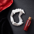 Flat lay of vampire fangs with a vampire costume collar and fake blood